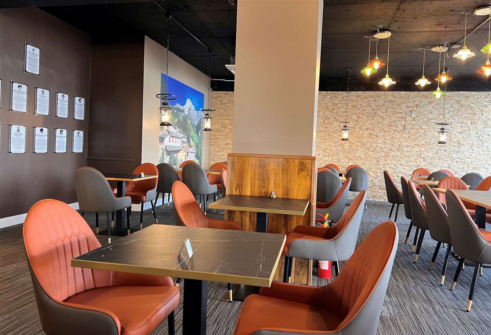 The dining room at Gurkha, with orange chairs and a Himalayan mural